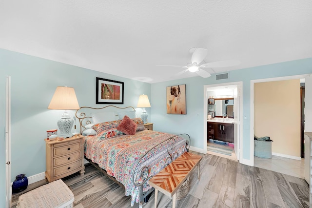 bedroom with ensuite bath, ceiling fan, and light wood-type flooring