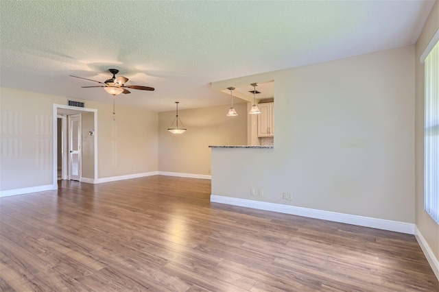 interior space with hardwood / wood-style flooring, ceiling fan, and a textured ceiling