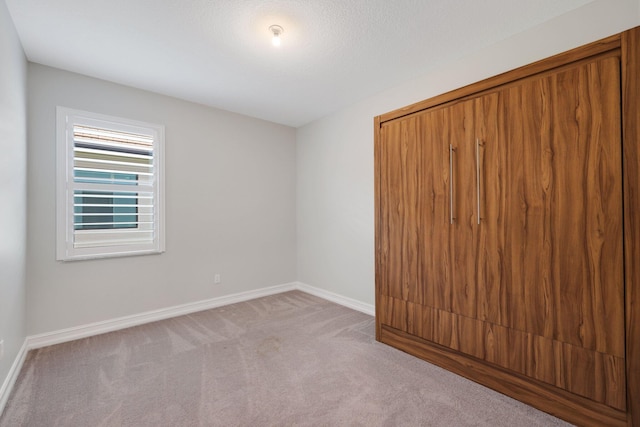 spare room featuring light colored carpet