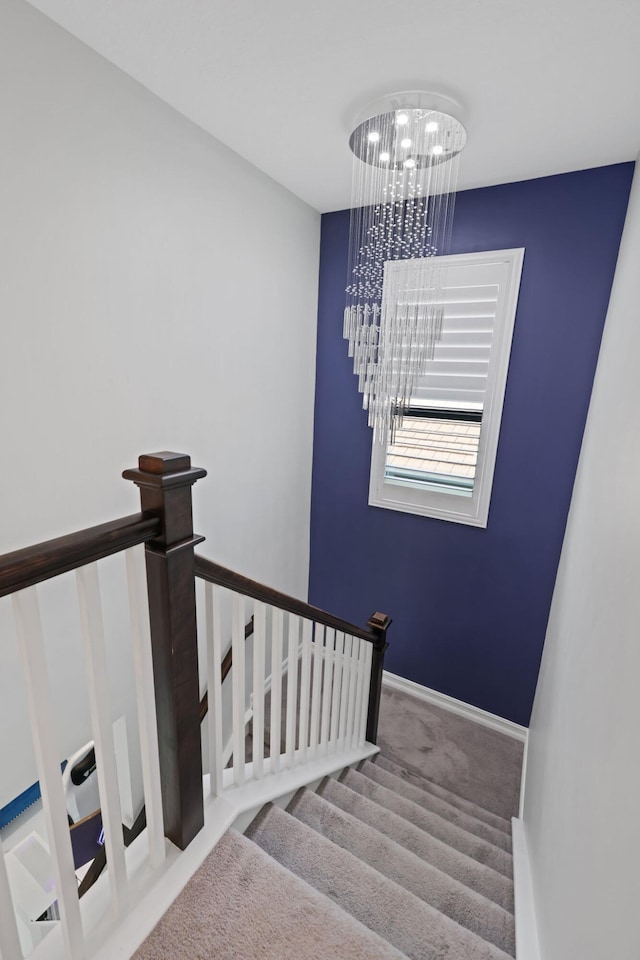 stairway featuring carpet and an inviting chandelier