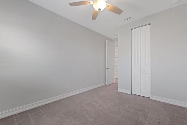 unfurnished bedroom featuring a closet, ceiling fan, and light colored carpet