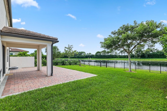 view of yard featuring a water view and a patio