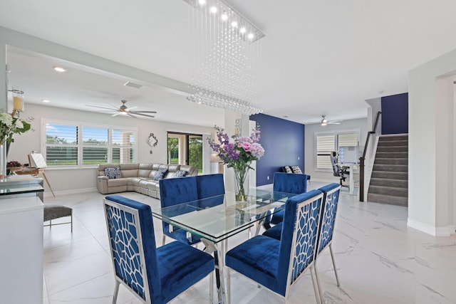 dining space with ceiling fan with notable chandelier