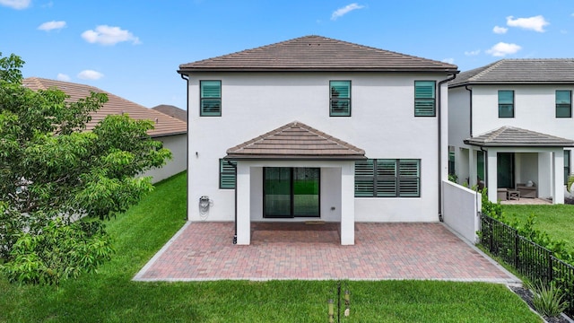 rear view of house with a lawn and a patio