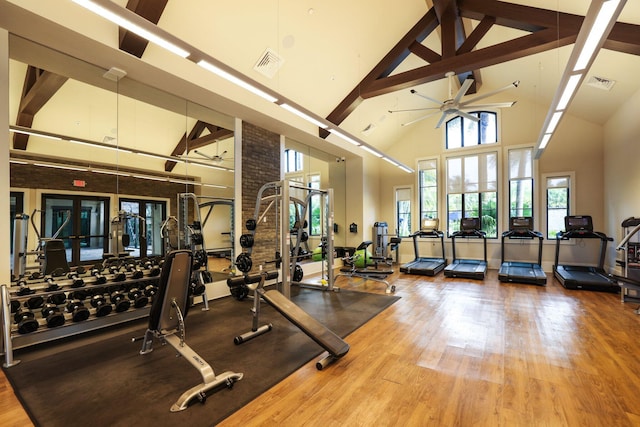 workout area with ceiling fan, wood-type flooring, and high vaulted ceiling