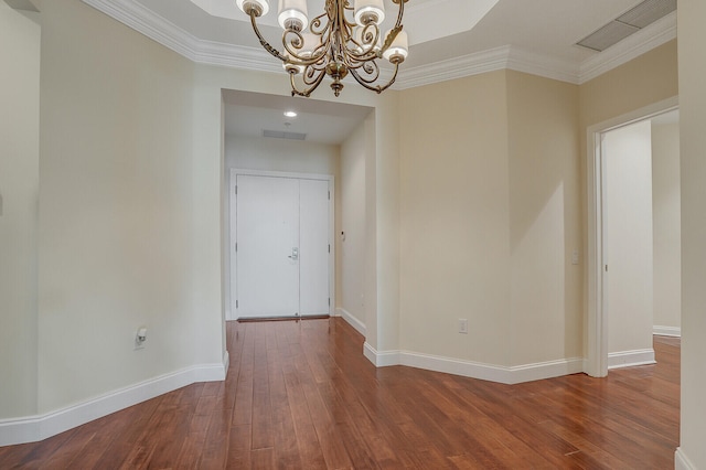 unfurnished room with a chandelier, wood-type flooring, and ornamental molding