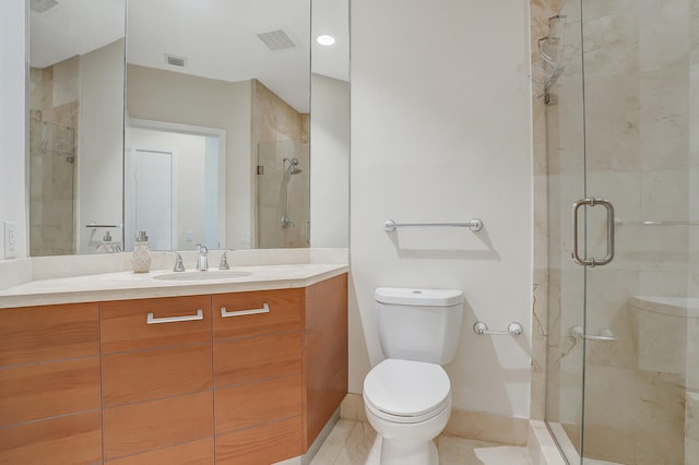 bathroom with tile patterned floors, vanity, a shower with shower door, and toilet