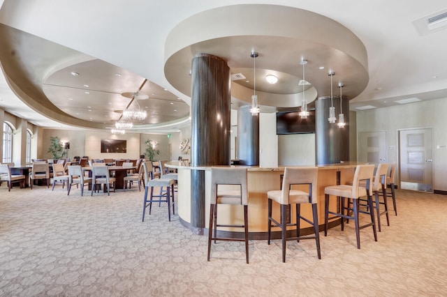 kitchen featuring decorative light fixtures, a raised ceiling, and light colored carpet