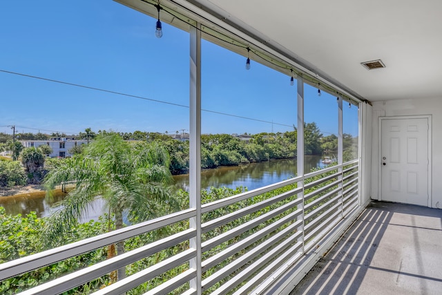 unfurnished sunroom featuring a water view