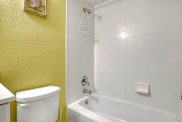 full bathroom featuring tiled shower / bath, vanity, and toilet