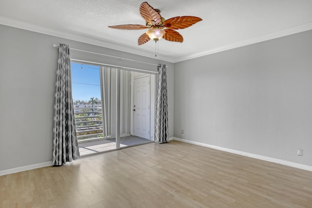 empty room with a textured ceiling, ornamental molding, light wood-type flooring, and ceiling fan