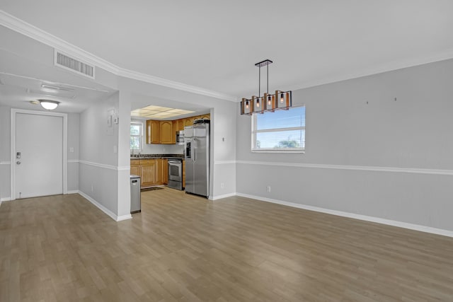 kitchen featuring light wood-type flooring, appliances with stainless steel finishes, crown molding, and a healthy amount of sunlight