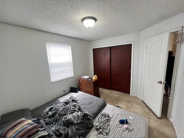 tiled bedroom featuring a closet and a textured ceiling