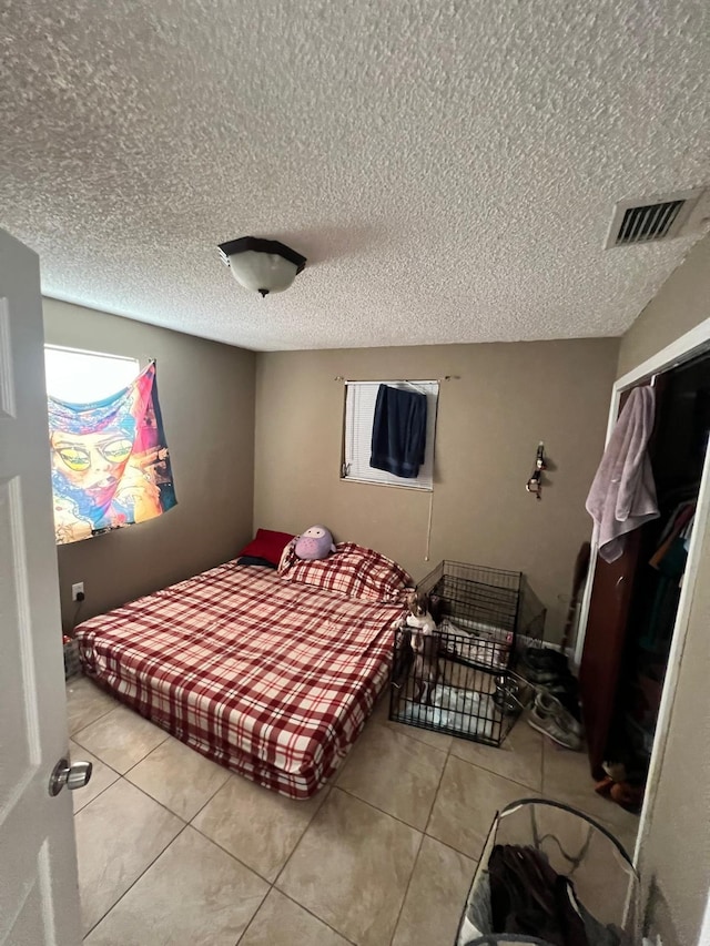 tiled bedroom with a textured ceiling