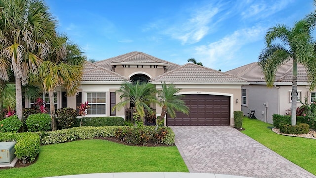 mediterranean / spanish home featuring a front yard and a garage