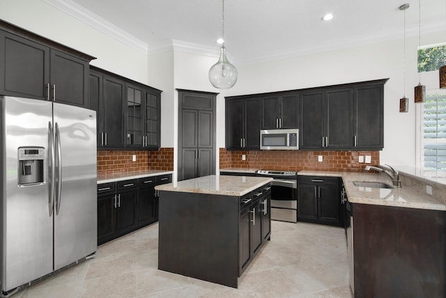 kitchen featuring appliances with stainless steel finishes, pendant lighting, a center island, and sink