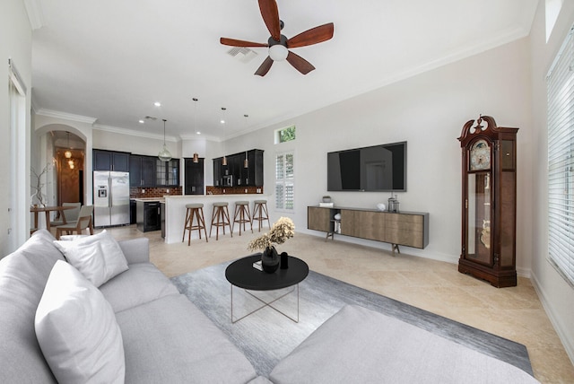 living room with ornamental molding and ceiling fan