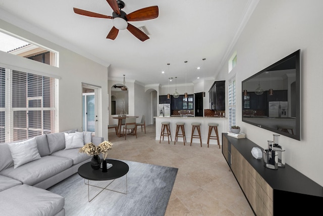 living room featuring light tile patterned flooring, crown molding, and ceiling fan