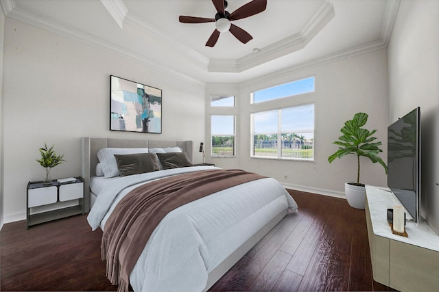 bedroom featuring ornamental molding, ceiling fan, a tray ceiling, and dark hardwood / wood-style flooring