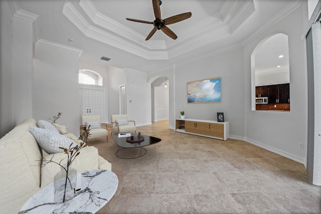 living room featuring crown molding, ceiling fan, and a tray ceiling