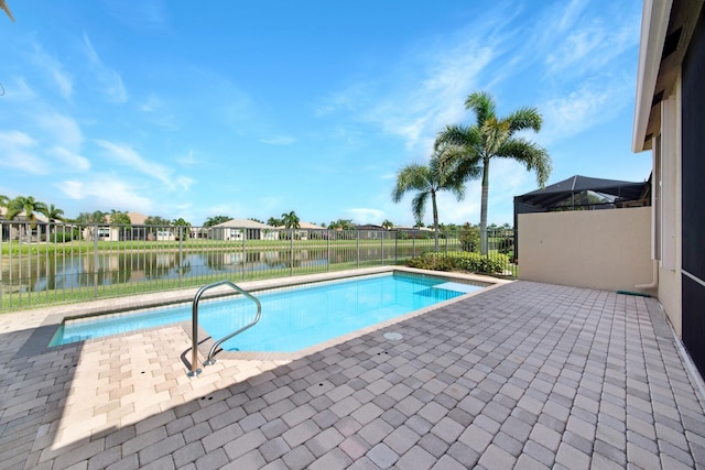 view of swimming pool featuring a water view, a patio area, and a lanai