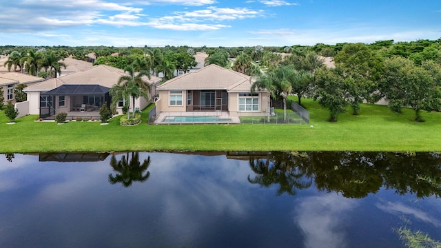 rear view of house featuring a water view, a lawn, and a lanai