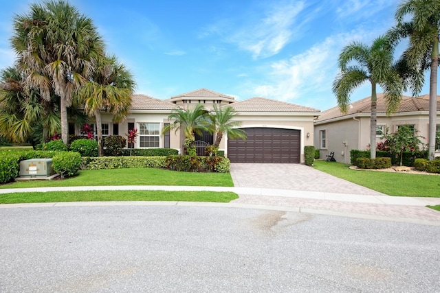 mediterranean / spanish-style house featuring a front yard and a garage