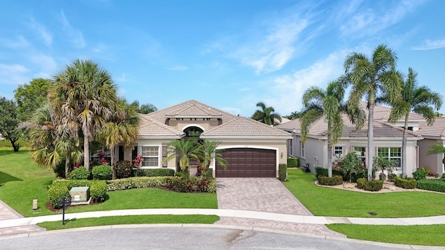 mediterranean / spanish-style house featuring a front lawn and a garage