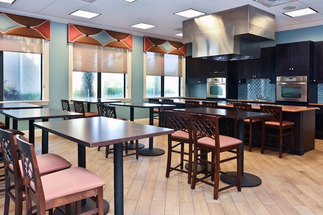 dining room with a drop ceiling and light hardwood / wood-style floors