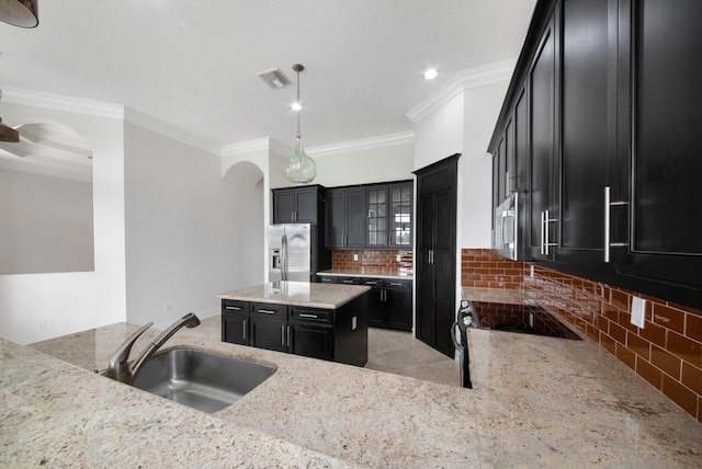 kitchen featuring stainless steel appliances, tasteful backsplash, sink, hanging light fixtures, and ornamental molding