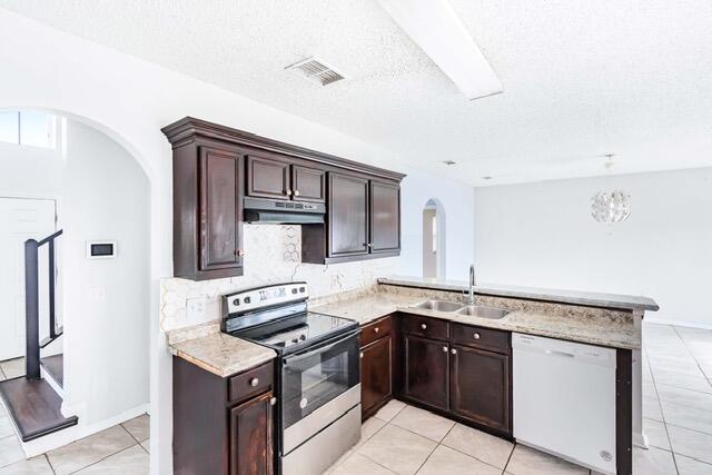 kitchen featuring sink, dishwasher, a textured ceiling, electric range, and kitchen peninsula