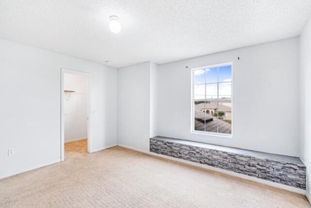 carpeted spare room featuring a textured ceiling