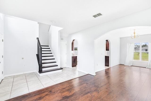 unfurnished living room featuring light hardwood / wood-style flooring and a notable chandelier