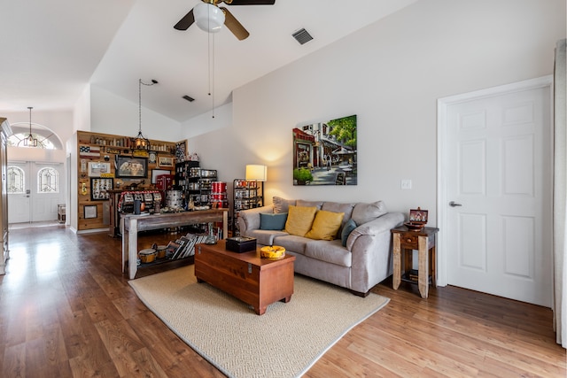 living room with hardwood / wood-style flooring, high vaulted ceiling, and ceiling fan