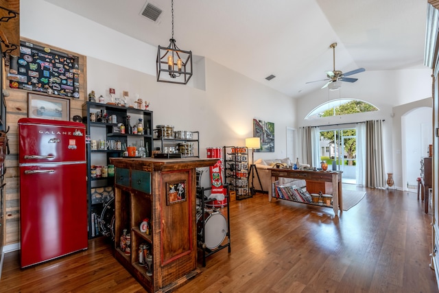 bar featuring high vaulted ceiling, wood-type flooring, ceiling fan with notable chandelier, and stainless steel fridge