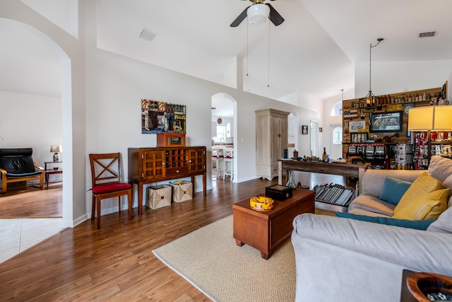 living room featuring ceiling fan, hardwood / wood-style flooring, and high vaulted ceiling