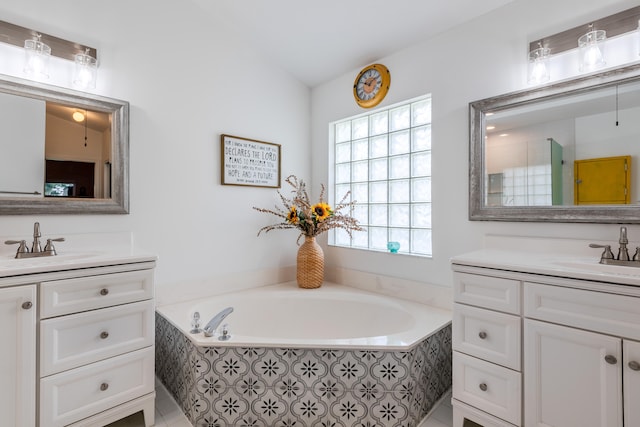 bathroom featuring vanity, a relaxing tiled tub, and tile patterned flooring