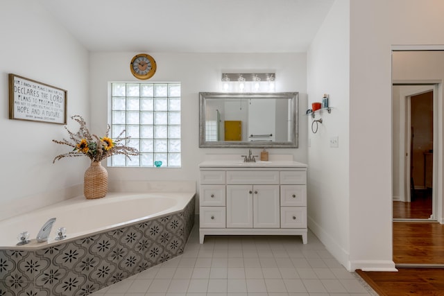 bathroom with vanity, tile patterned flooring, and tiled tub