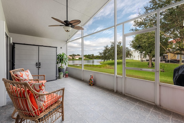 sunroom / solarium with a water view and ceiling fan