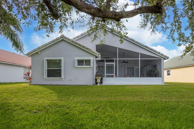 rear view of property with a yard, a sunroom, and ceiling fan