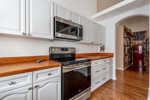 kitchen featuring appliances with stainless steel finishes, white cabinetry, and butcher block countertops