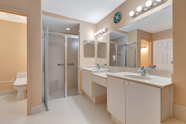 bathroom with vanity, toilet, a shower with shower door, and tile patterned flooring