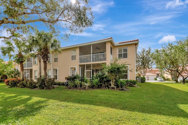 back of property with a lawn, a balcony, and a garage