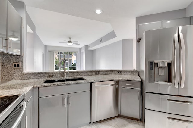 kitchen featuring sink, white cabinets, appliances with stainless steel finishes, light stone counters, and ceiling fan