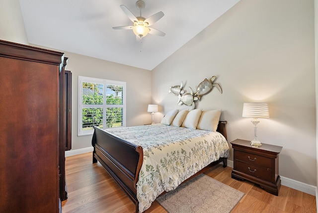 bedroom featuring hardwood / wood-style floors, vaulted ceiling, and ceiling fan