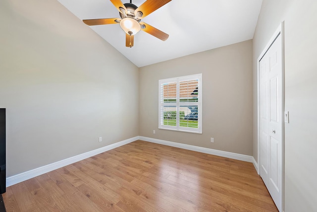 unfurnished bedroom featuring light wood-type flooring, a closet, vaulted ceiling, and ceiling fan