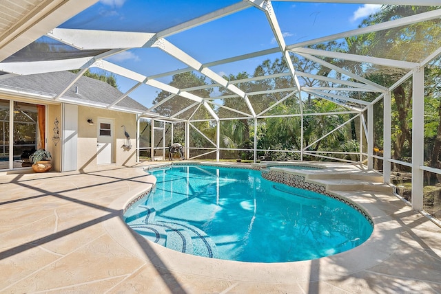 view of pool with an in ground hot tub, a patio, and a lanai