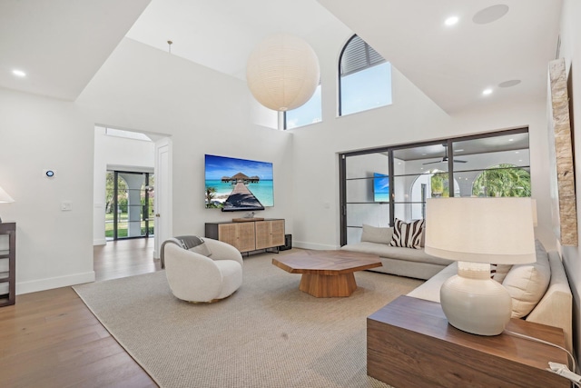 living room with a healthy amount of sunlight, high vaulted ceiling, and light wood-type flooring