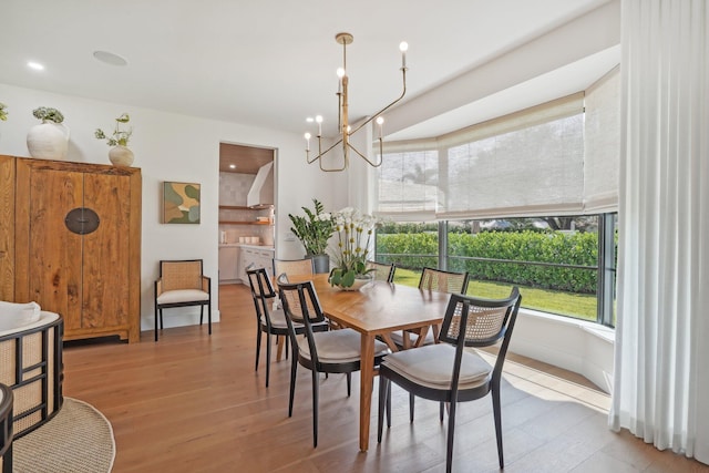 dining space with a notable chandelier and light hardwood / wood-style flooring