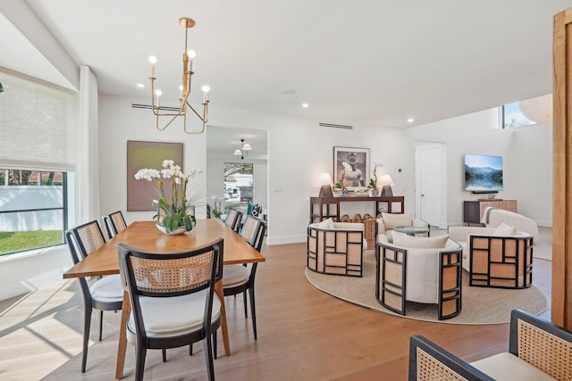 dining room featuring light hardwood / wood-style flooring, plenty of natural light, and an inviting chandelier